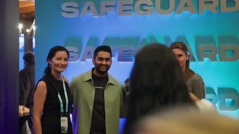 Attendees in front of the lit Safeguard wall at night