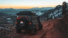 A Jeep on a mountain road above Colorado Springs at dusk