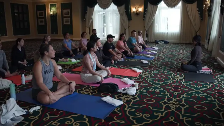Attendees on yoga mats in the Broadmoor ballroom