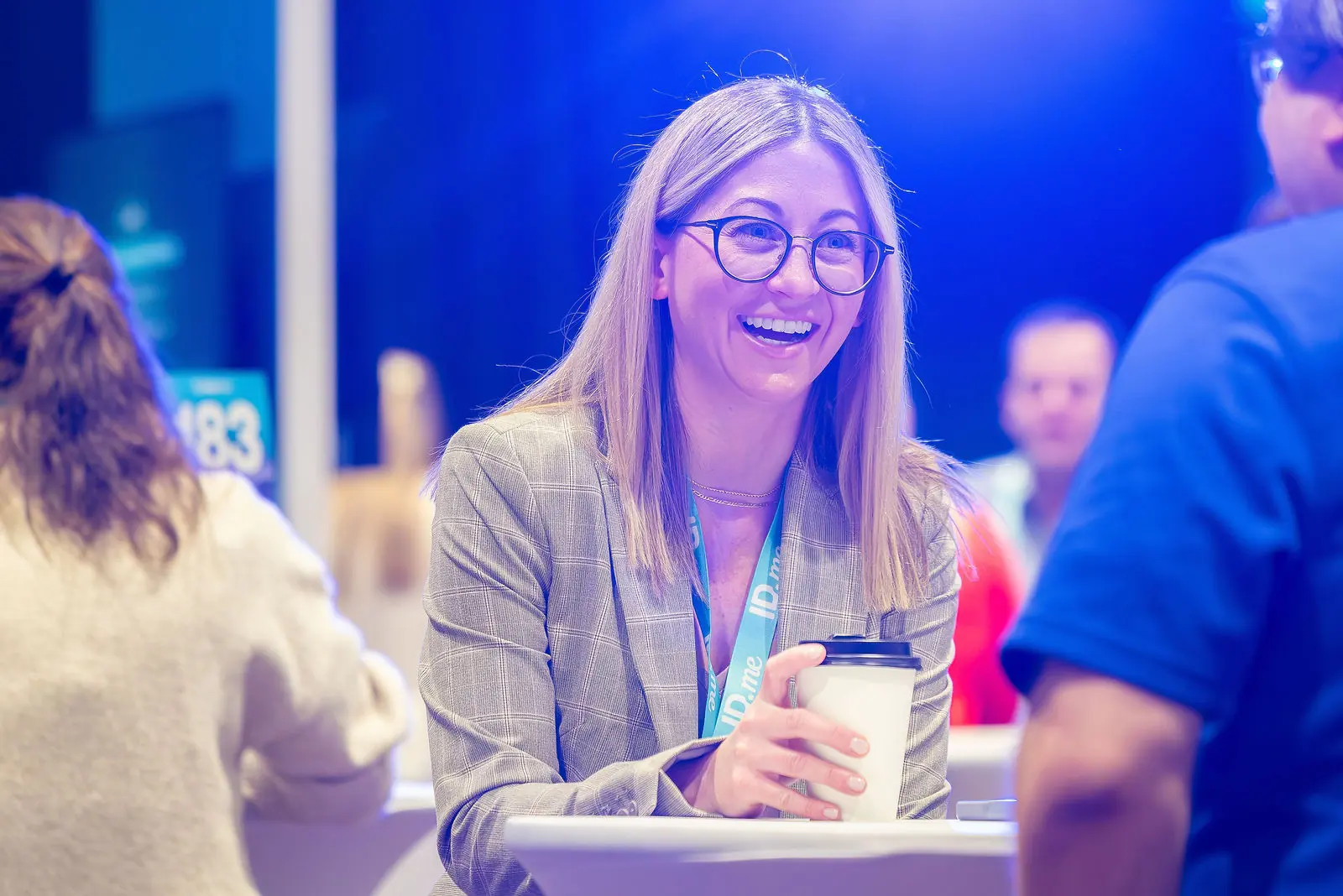 An attendee smiling over coffee between meetings