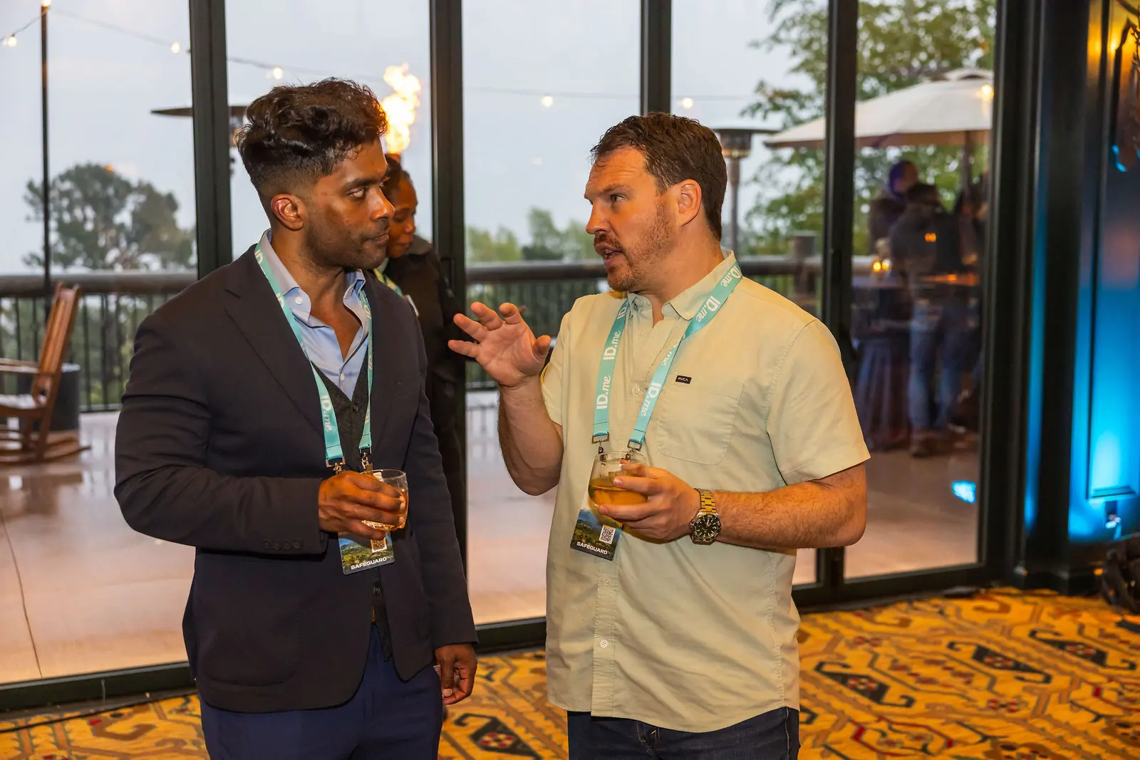 Two attendees laughing over drinks at the reception