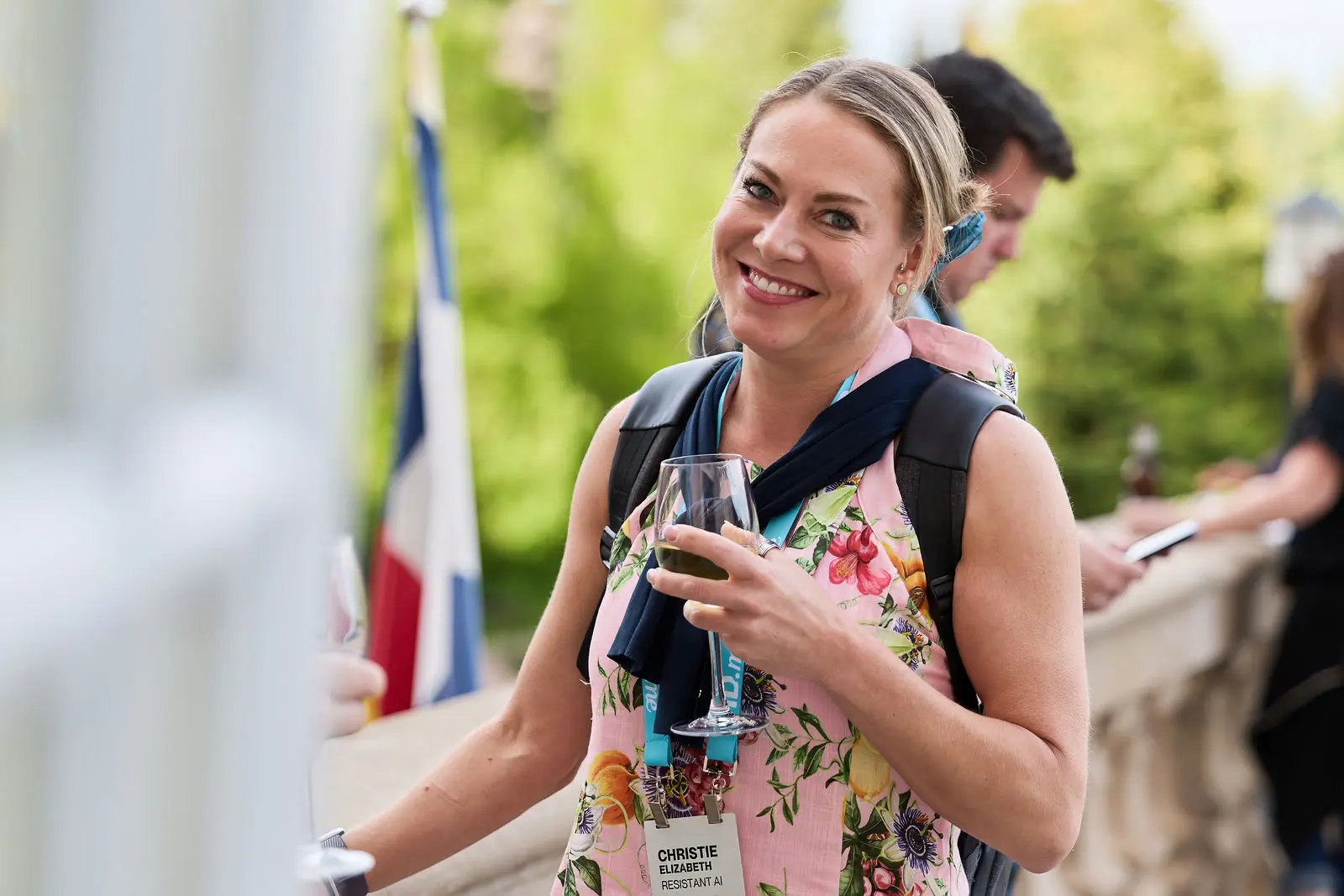 An attendee laughing with a drink at the opening reception