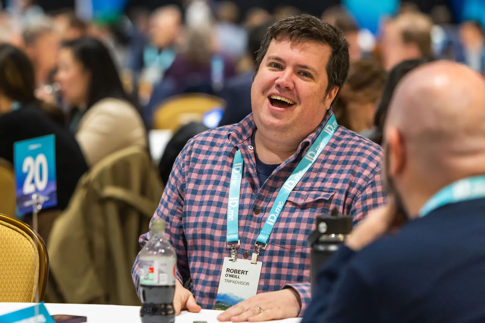 A roundtable guest laughing over lunch at table twenty