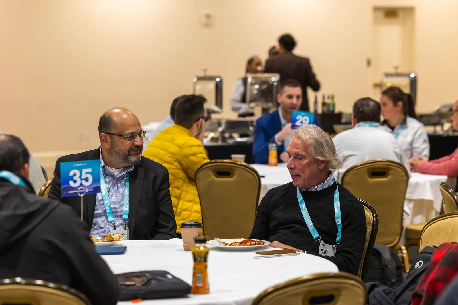 Two attendees deep in conversation at roundtable thirty-five